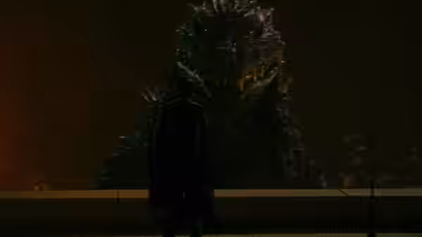 A man stands before Godzilla across a barrier at night