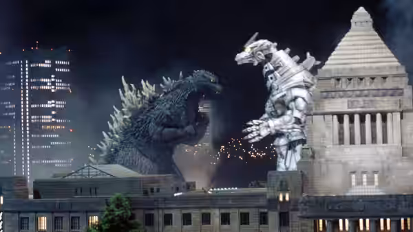 Godzilla faces the silver Kiryu beside a stone government building at night
