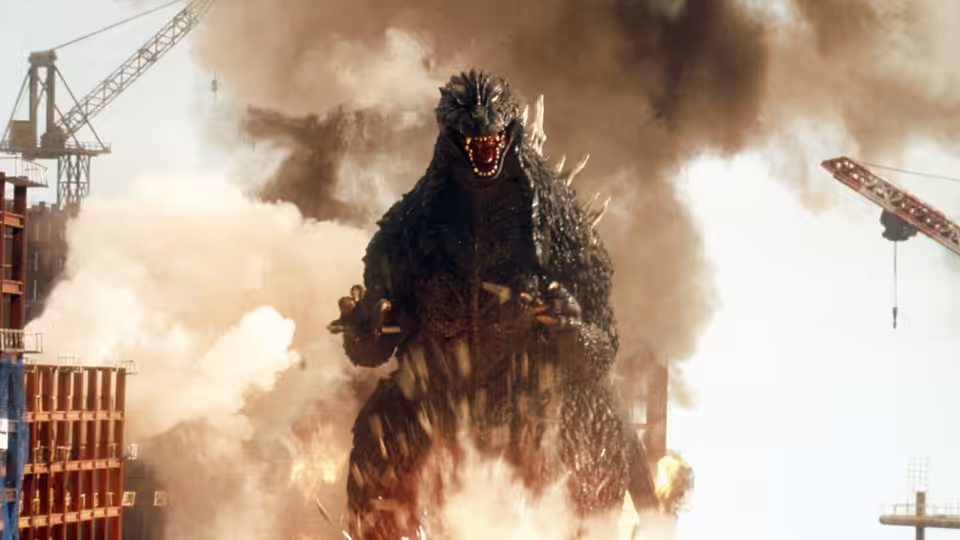 Godzilla rises amid smoke and flames at a construction site