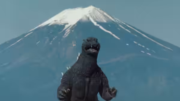 Godzilla stands before snow-capped Mount Fuji
