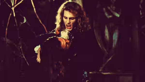 Claudia (Kirsten Dunst) biting a victim's neck in a dark setting