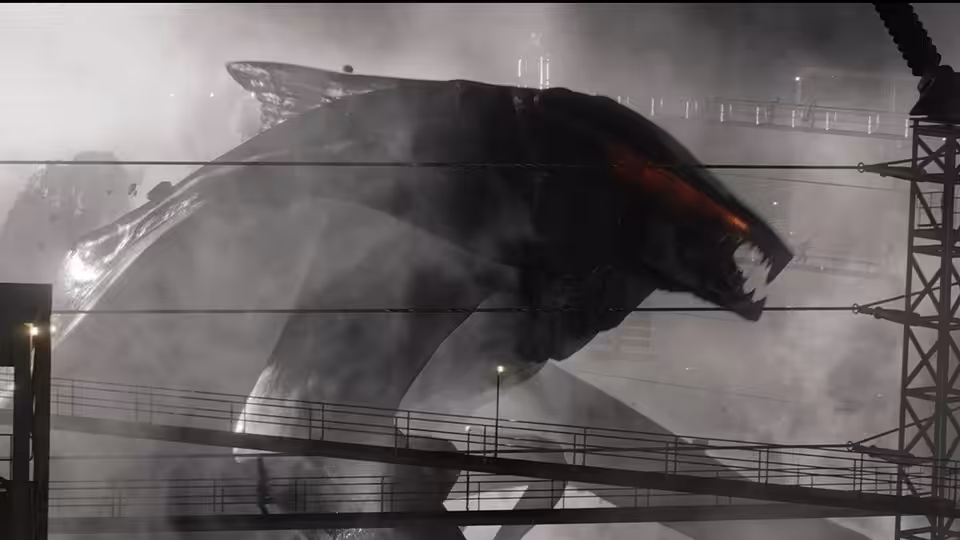 A giant winged creature looms over an elevated walkway amid smoke and industrial structures