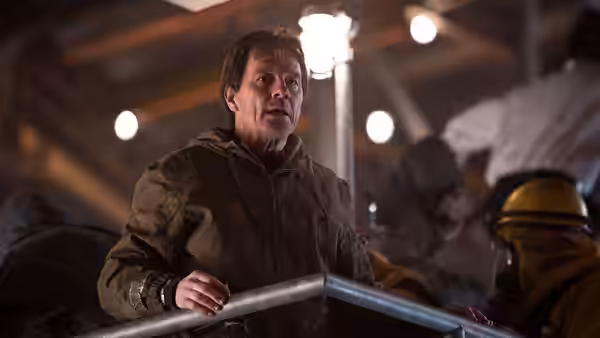 Joe Brody (Bryan Cranston) grips a railing among evacuees in a crowded shelter