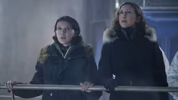 Madison and Emma Russell grip a railing and look upward