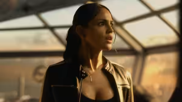 Maia Simmons (Eiza Gonzalez) looks startled inside a glass-roofed facility