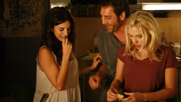 Juan Antonio (Javier Bardem) laughs between Vicky and Cristina as they examine an object