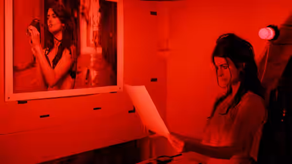 Cristina (Scarlett Johansson) handles a photographic print in a red-lit darkroom