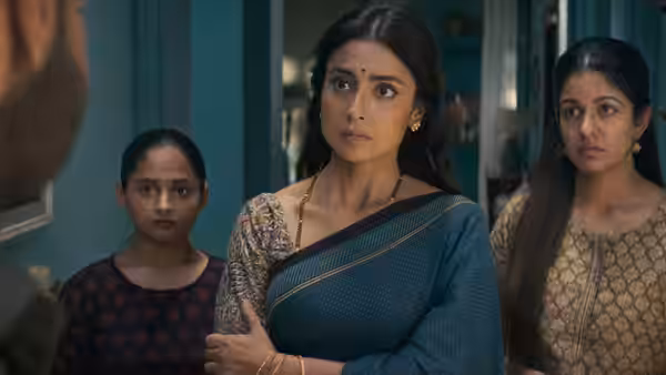 Nandini (Shriya Saran) stands with two girls, facing someone in a doorway