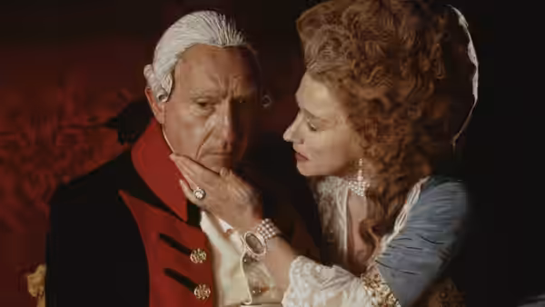 George III and Queen Charlotte sharing a tender moment in a red room