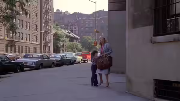 Gloria (Gena Rowlands) holds hands with Phil on an urban sidewalk