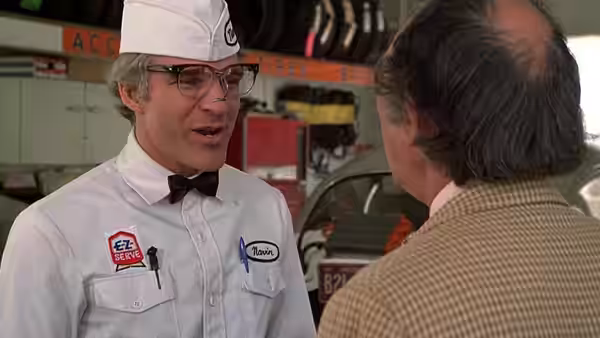 Navin (Steve Martin), dressed as a service station attendant, talks with a customer