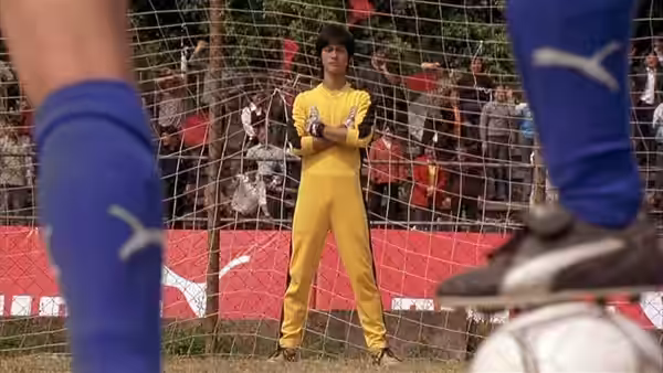 Sing (Stephen Chow) stands with folded arms in goal as opposing players approach
