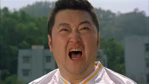 A stocky player in a white-and-yellow jersey shouts on the field