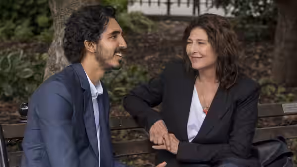 Dev Patel (Joshua) and Catherine Keener (Julie) sit together on a park bench