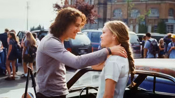 Cameron James (Joseph Gordon-Levitt) rests his hand on Bianca Stratford's shoulder by a car