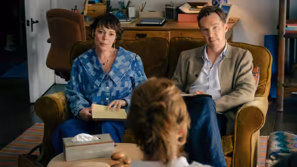 Ivy Rose (Olivia Colman) and Theo Rose (Benedict Cumberbatch) sit facing a woman at home