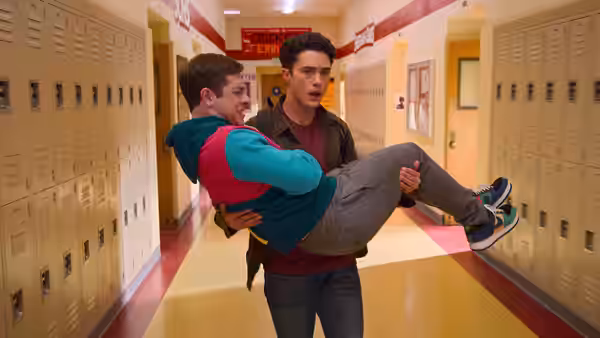 Paxton carries Ben through a school hallway lined with lockers