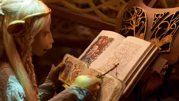 Brea (Anya Taylor-Joy) studies an illustrated book beside an ornate chair