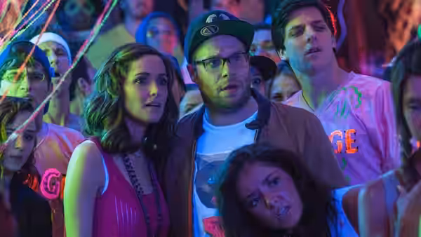Kelly and Mac watch Teddy at a crowded fraternity party