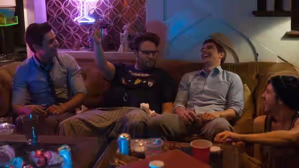 Mac, Pete and Teddy laugh together on a couch at a party