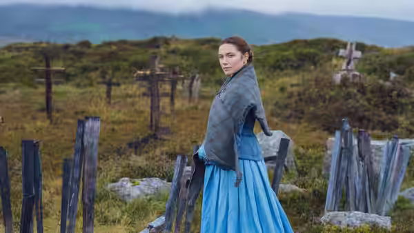 Lib Wright (Florence Pugh) looks back among weathered gravestones on a hillside