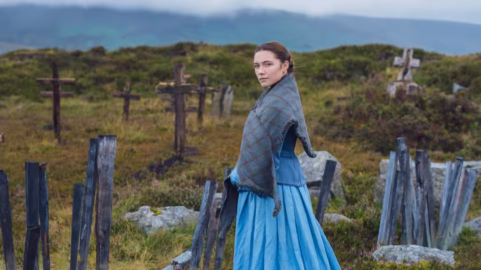Lib Wright (Florence Pugh) looks back among weathered gravestones on a hillside