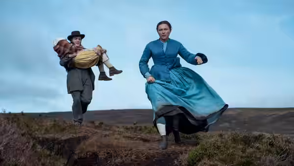 Lib Wright (Florence Pugh) runs across the moor as Will Byrne carries Anna