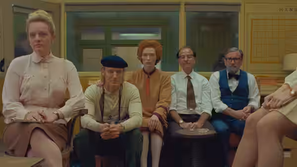 A group of people sit together in a room with a Kansas map on the wall