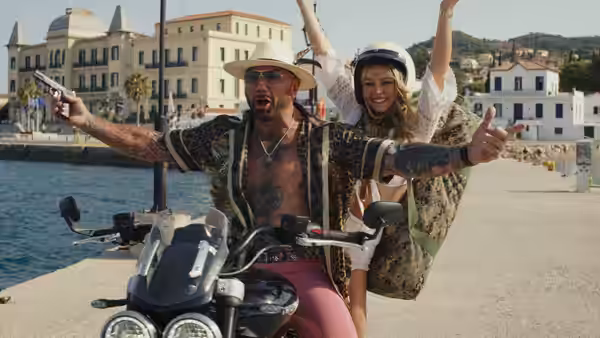 Duke Cody (Dave Bautista) rides a motorcycle with Birdie Jay (Kate Hudson) behind him