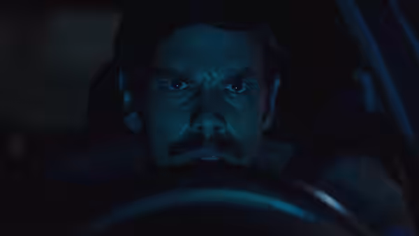 Pedro (Ezequiel Rodríguez) grips the steering wheel, staring ahead in the dark