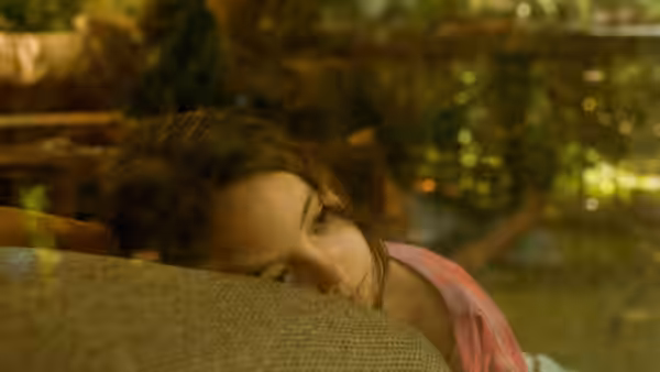 Sol (Naíma Sentíes) rests her head on a cushion in a garden