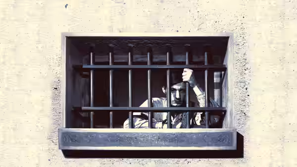 Fontaine peers through barred prison-cell window, raising a hand beside the iron bars