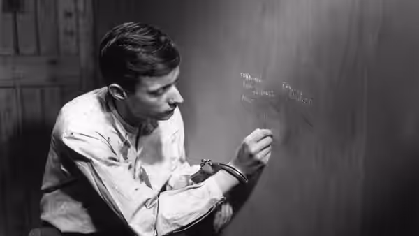 Fontaine scratches a message into the prison wall with a small tool