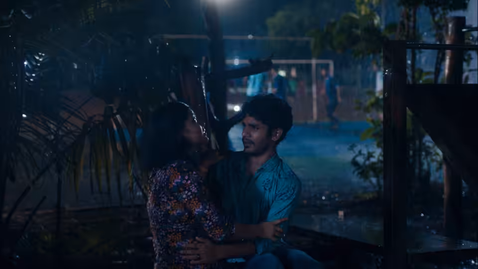 Anu (Divya Prabha) embraces Shiaz (Hridhu Haroon) beneath a shelter in the rain
