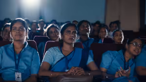 Prabha (Kani Kusruti) sits among fellow nurses watching a presentation in an auditorium