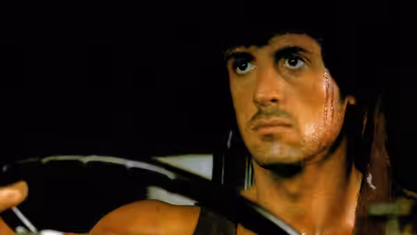 John Rambo (Sylvester Stallone) grips the steering wheel inside a vehicle