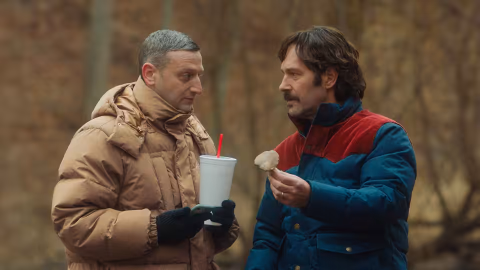 Craig Waterman (Tim Robinson) and Austin Carmichael (Paul Rudd) talk in the woods over a drink and snack