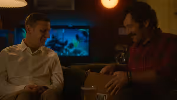 Craig Waterman (Tim Robinson) and Austin Carmichael (Paul Rudd) sit together indoors, smiling over a drink
