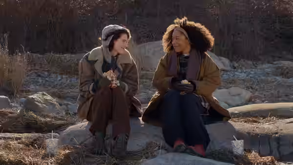 Agnes (Eva Victor) and Lydie (Naomi Ackie) sit together on rocks, talking