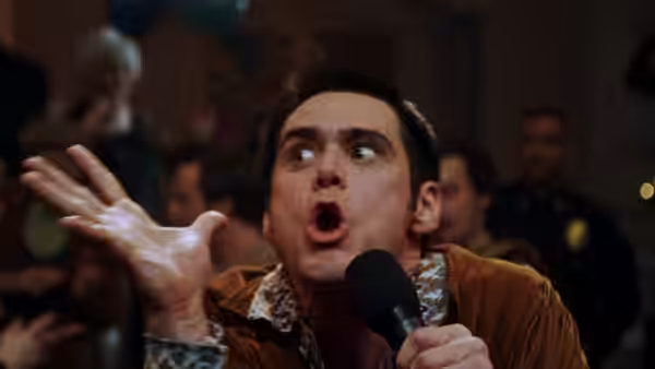 Cable Guy (Jim Carrey) sings into a microphone, gesturing wildly