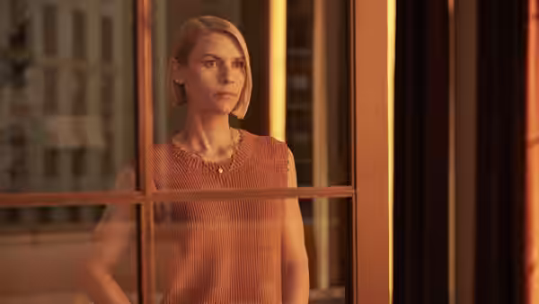 Rachel (Claire Danes) stands behind glass doors, looking out