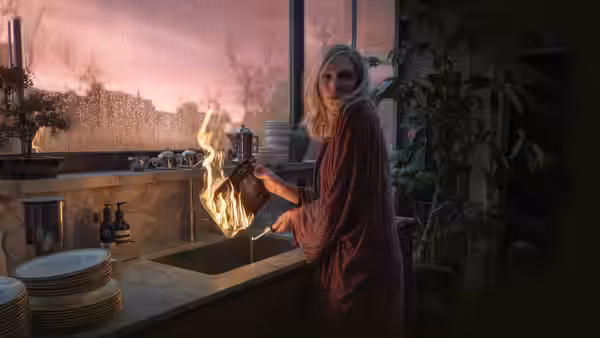 Catherine Ravenscroft (Cate Blanchett) holds a flaming object beside the kitchen sink