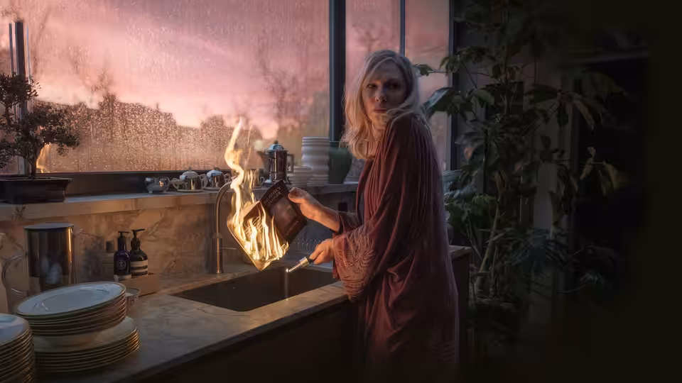 Catherine Ravenscroft (Cate Blanchett) holds a flaming object beside the kitchen sink