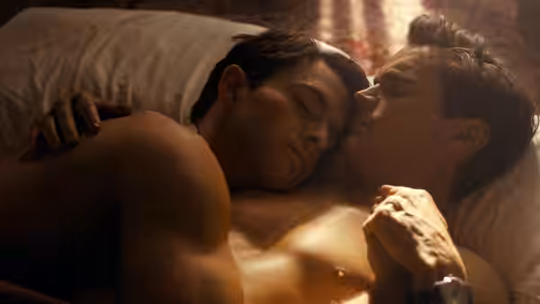 Tim Laughlin (Jonathan Bailey) rests against Hawk Fuller (Matt Bomer) in bed