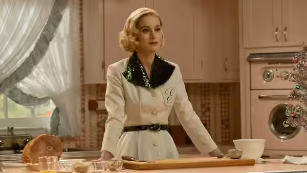 Elizabeth Zott (Brie Larson) stands at a kitchen counter with baking ingredients