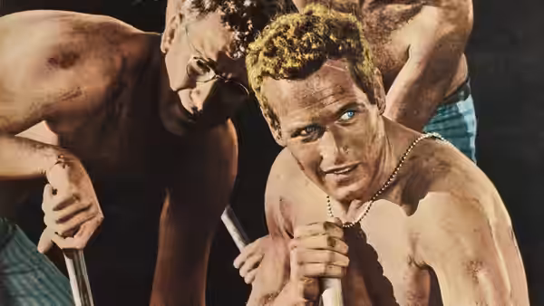 Luke Jackson (Paul Newman) grips a shovel among fellow prisoners digging