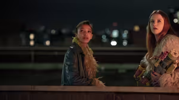 Jen (Mairéad Tyers) and Carrie (Sofia Oxenham) stand by a railing at night, holding toy blasters