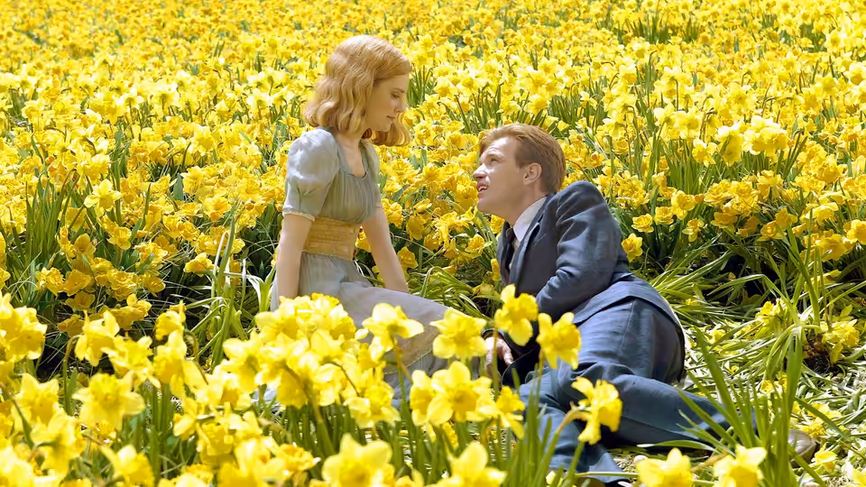 Young Ed Bloom and Sandra sit together in a field of yellow flowers