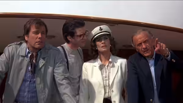 Chief Inspector Dreyfus points ahead beside a woman and two men aboard a boat