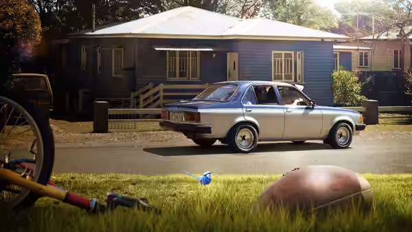 A silver sedan sits outside a blue house, with a blue butterfly above the grass